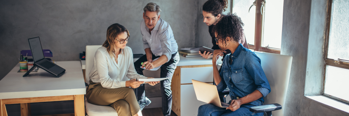 Group of four professionals in a discussion at a casual office setting, utilizing Biteable video maker.